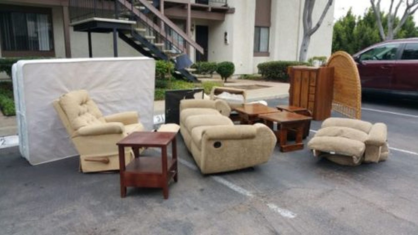 Furniture pile in a San Diego apartment parking lot ready for a cheap haul